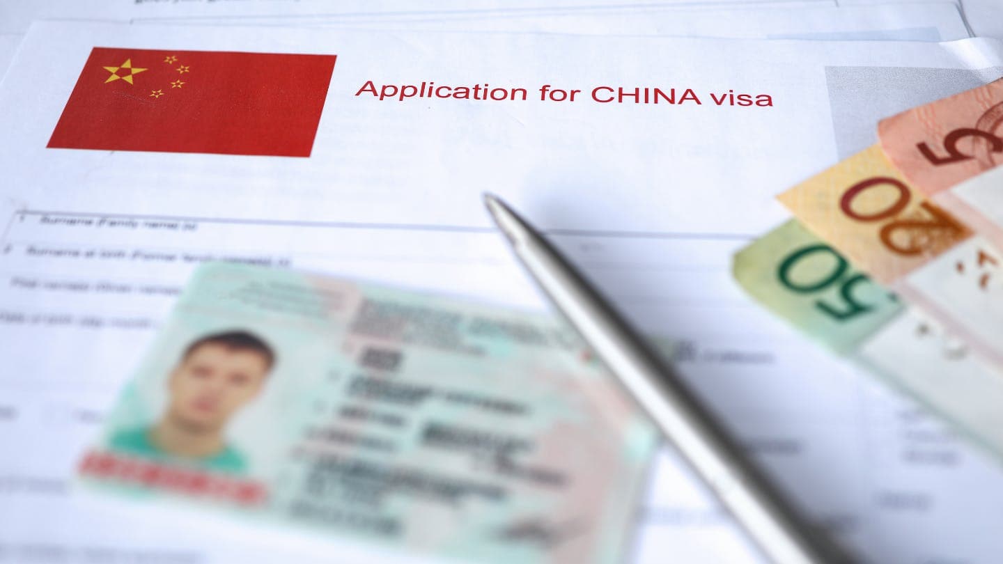 china visa application with passport and a pen