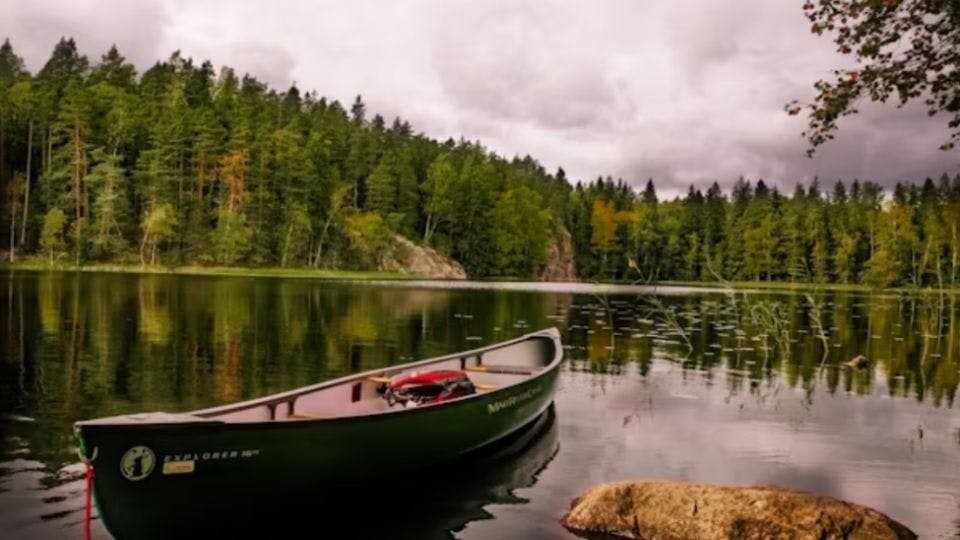 Serene lake with boat in Finnish forest.