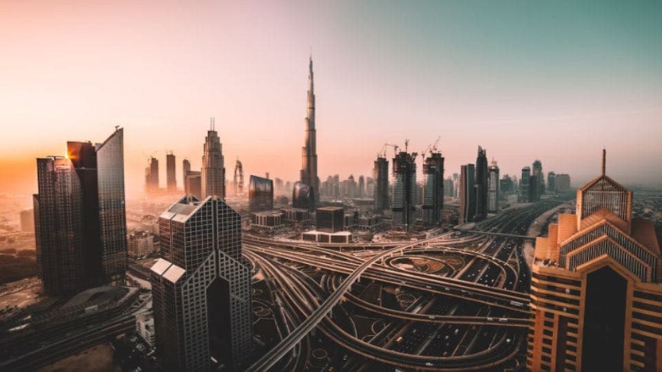 Aerial view of Dubai skyline at sunset.